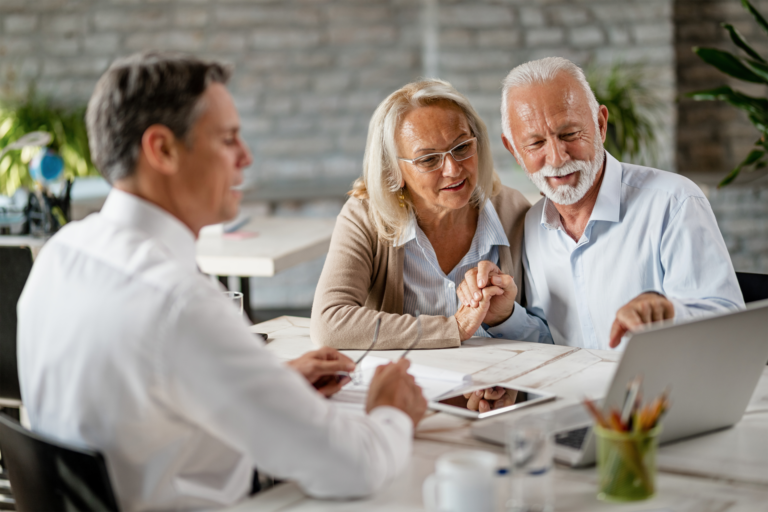 happy-senior-couple-holding-hands-using-laptop-while-having-meeting-with-financial-advisor-office-senior-man-is-pointing-something-laptop Kopie