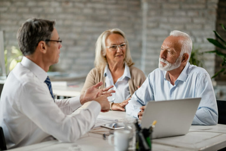 mature-couple-meeting-bank-manager-communicating-with-him-during-consultations-office