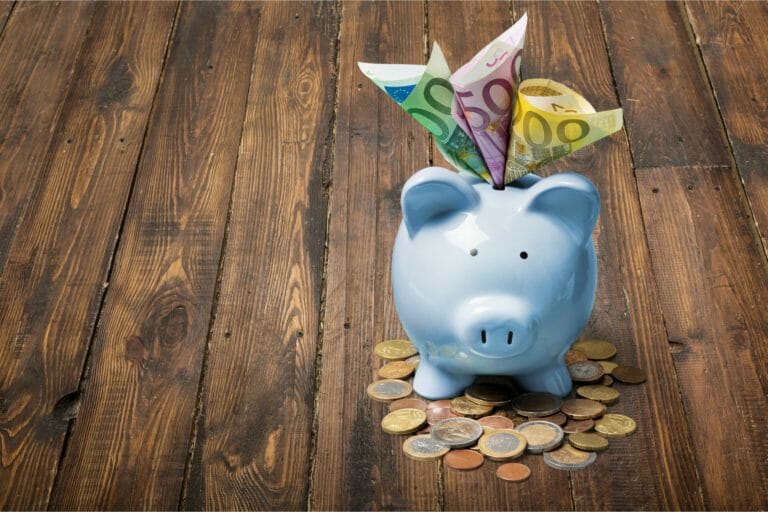 Piggy bank with money on wooden background